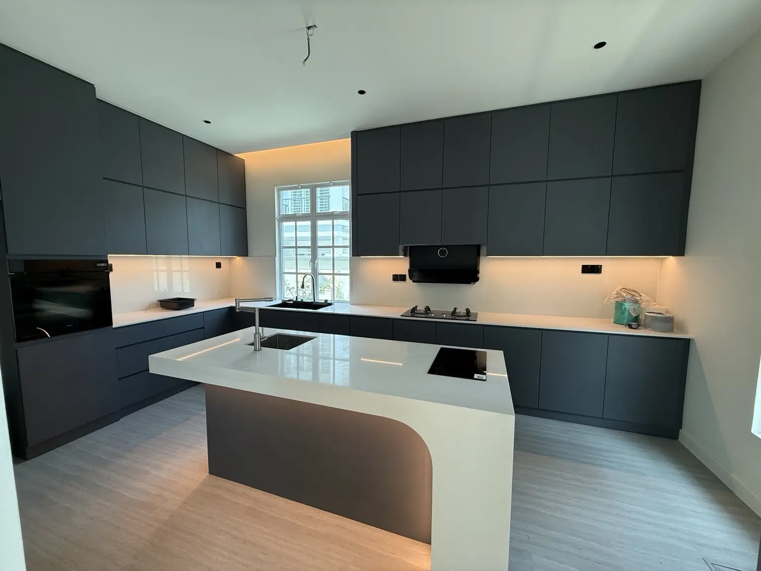 Kabinet dapur moden berwarna gelap dengan island melengkung