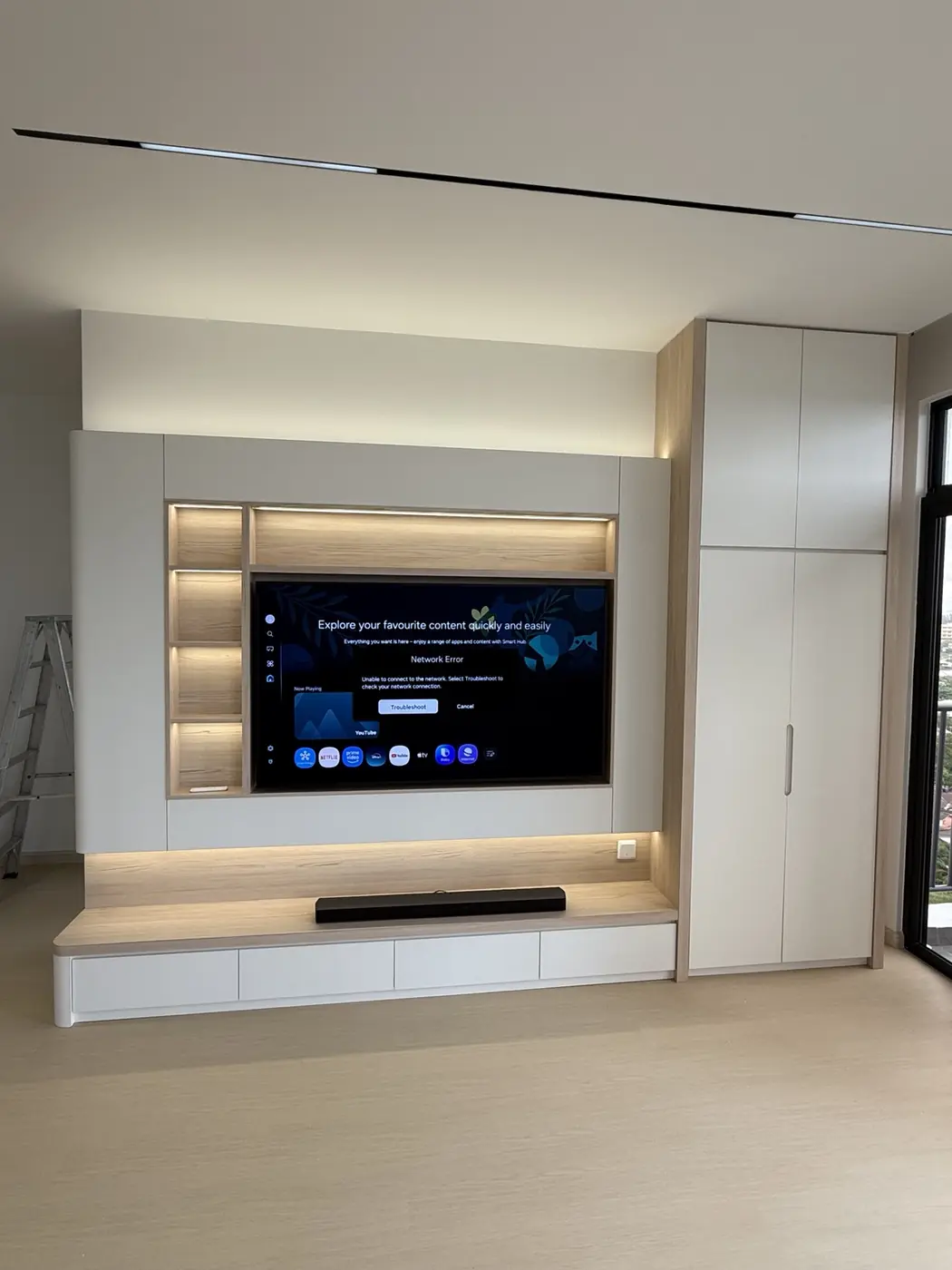 Kabinet TV minimal berwarna cerah dengan pencahayaan LED